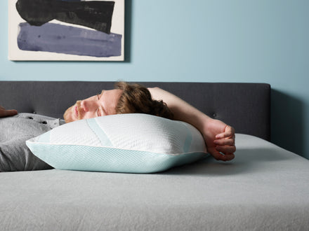 Man sleeping in bed with his head on a pillow.