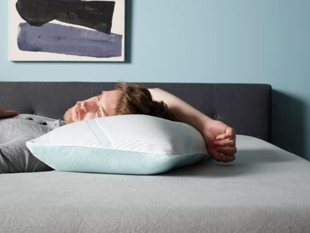 Man sleeping in bed with his head on a pillow.