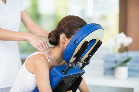 Woman receiving a massage in a massage chair.