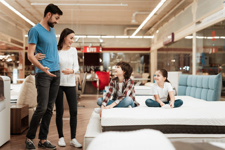 A family testing mattresses in a mattress store.