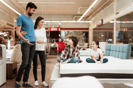 A family testing mattresses in a mattress store.