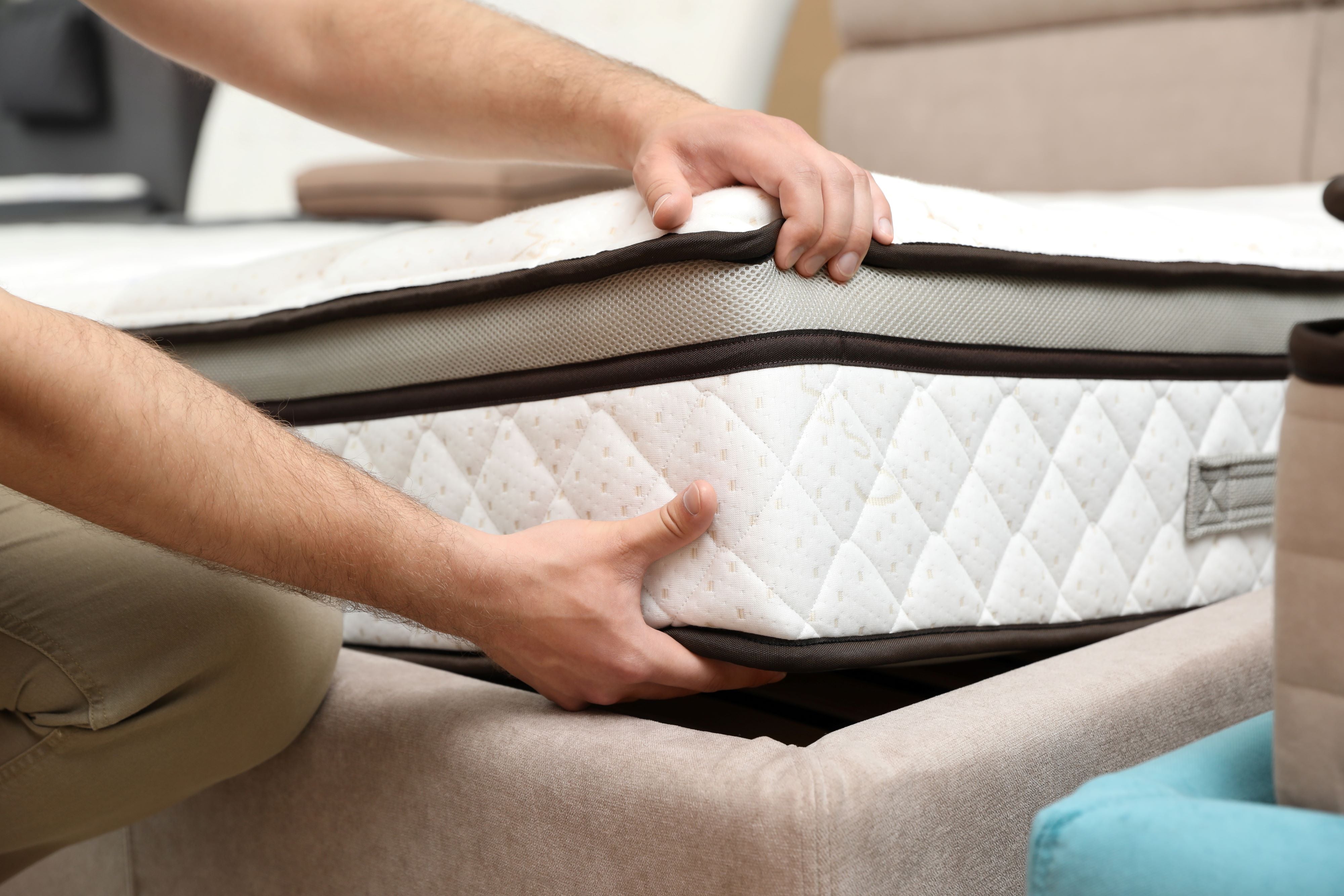 Close up of a man choosing new hybrid mattress in store.