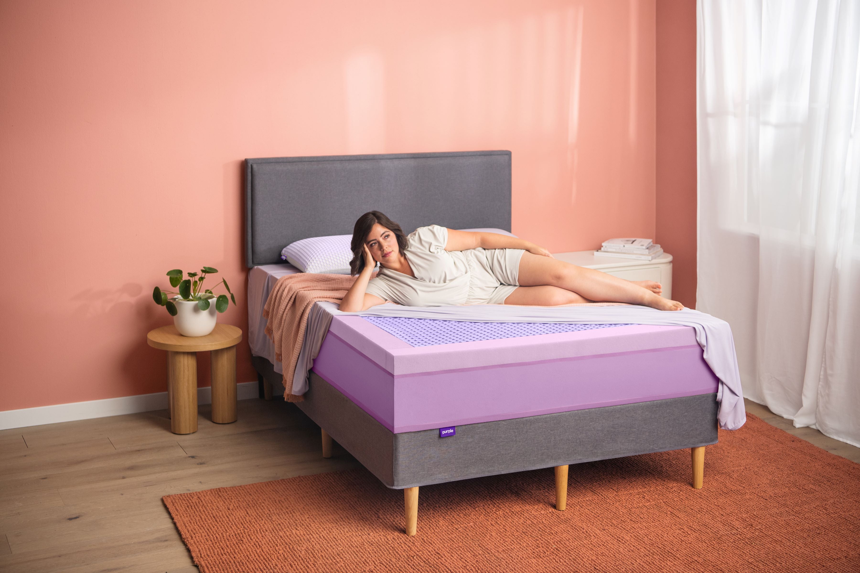 Woman lying on her side on a purple mattress
