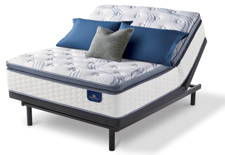 Serta mattress on adjustable base with white background and blue pillows
