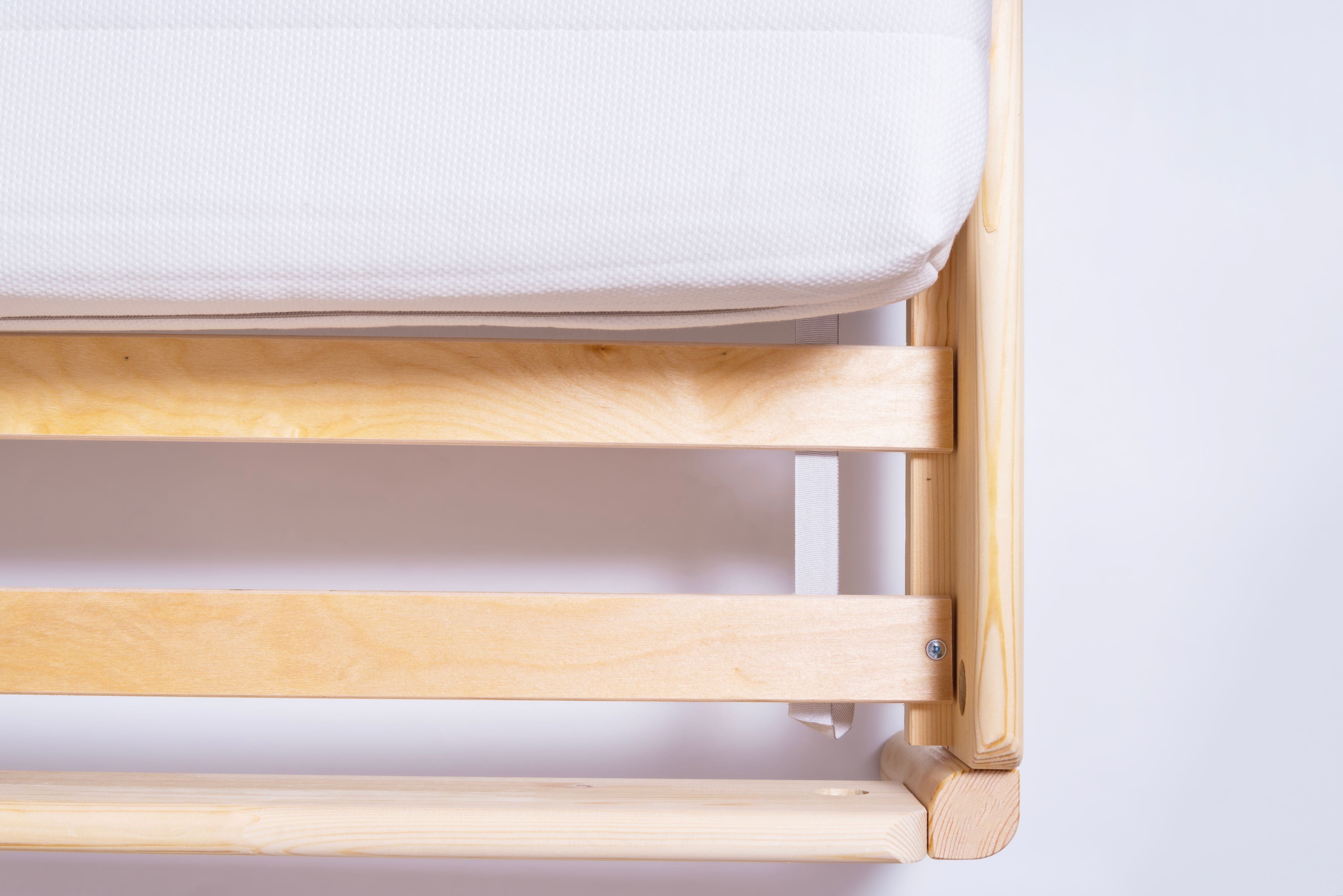 White mattress on wooden frame